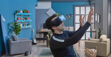 Sanal gerçeklik gözlüklü, dekoratif mavi duvar arka planlı bir adam..