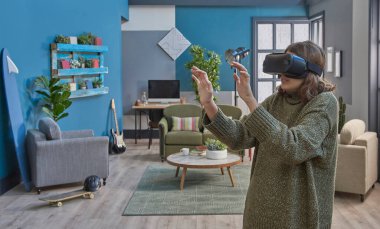 Kız sanal gerçeklik gözlüğü takıyor, yakın plan, mavi oturma odası yeşil kanepe dekorasyonu arka plan.