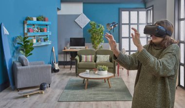 Kız sanal gerçeklik gözlüğü takıyor, yakın plan, mavi oturma odası yeşil kanepe dekorasyonu arka plan.