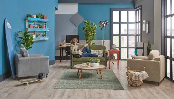 Girl play guitar in the room, decorative interior style with blue wall furniture sofa armchair bookshelf working table.