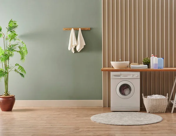 Çamaşır odası tarzında çamaşır makinesi, iç mekan konsepti, kirli çamaşır dekoru sehpası ve vazo dolusu bitki. Tahta bank, lavabo ve havlu..
