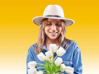 Genç kız, beyaz gül çiçeğini renkli duvar arkasında saklıyor..