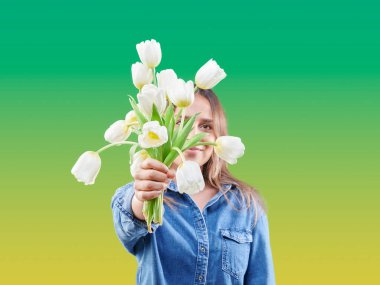 Genç kız, beyaz gül çiçeğini renkli duvar arkasında saklıyor..