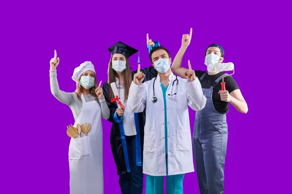 Chef, Graduated girl, doctor and painter man, group of various profession in pandemic and wear mask, colorful background. They are showing up them finger.