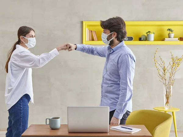 Two people wearing face mask in the workplace is greeting concept during the pandemic, social distance concept.