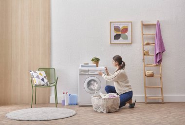 Laundry room washing machine and dirty clothes decorative modern style. Woman is taking or put clothes from the machine.