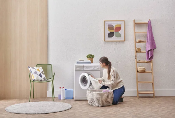 Laundry room washing machine and dirty clothes decorative modern style. Woman is taking or put clothes from the machine.