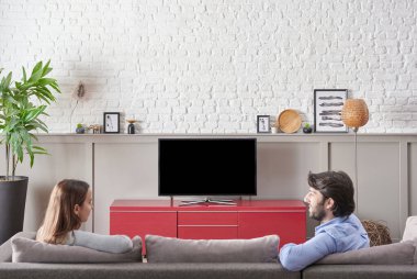 Couples are watching television in the decorative room, red unit, white brick wall, frame lamp concept, close up screen style.