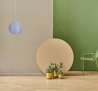 Renkli yuvarlak, altın vazo ve yeşil metal koltuklu gri ve yeşil duvar arkası. Lamba dekorasyon biçimi.