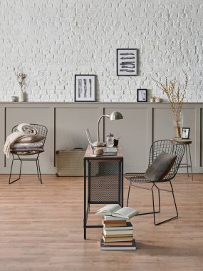 Çalışma odası ahşap masa dizüstü bilgisayarı, metal siyah koltuğu, poster tuğlası duvarı..