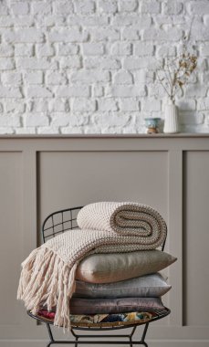 Siyah metal koltukta yastık ve battaniye katlanır, klasik kahverengi duvar ve beyaz tuğla arka plan ev eşyası hala yaşam konsepti.