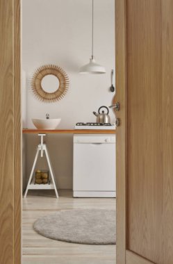 Ahşap kapıyı kapat, mutfakta bulaşık makinesi ve lavabo aynası lambası ve buzdolabı ile dekoratif stil..