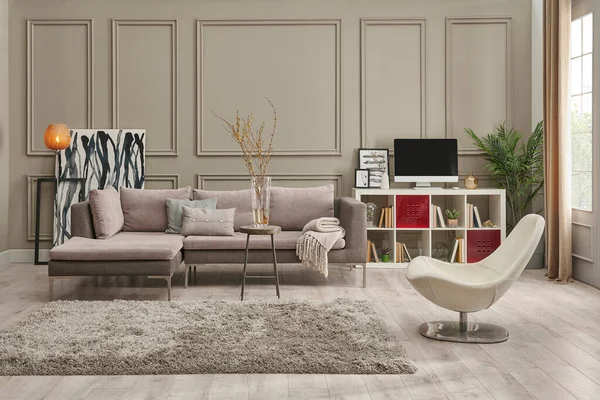 Kahverengi duvardaki gri kanepe, ev dekorasyonu masa halısı ve sandalye stili..