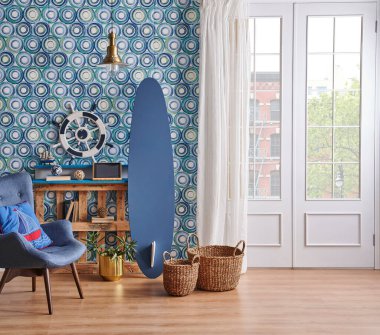 Modern oturma odası, mavi duvar kağıdı, dekoratif ahşap palet raf, sörf tahtası tarzı, koltuk altın lambası ve yeşil bitki tarzı..