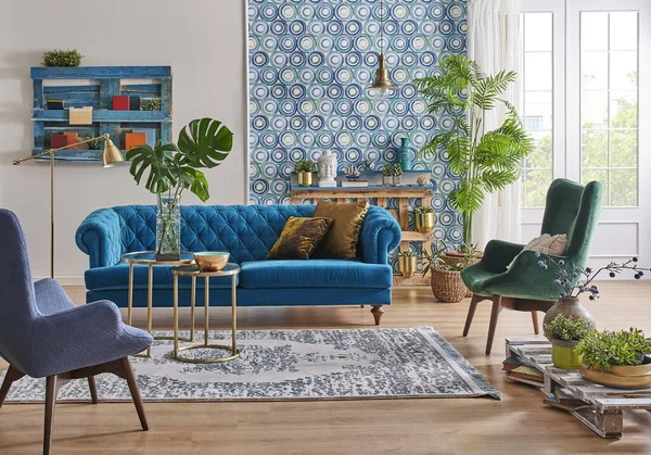 Blue wallpaper and sofa furniture style, decorative wooden palette bookshelf, gold lamp and middle table, vase of green plant, carpet and city view background.