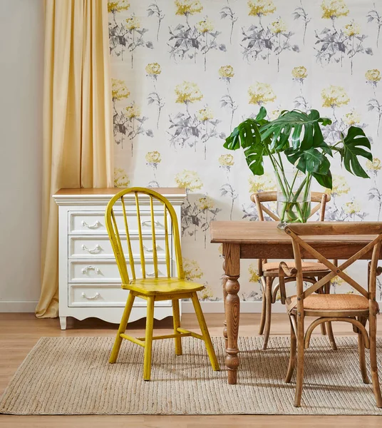 Modern wallpaper background in the room, wooden furniture table chair concept and cabinet, yellow carpet and green vase of plant.