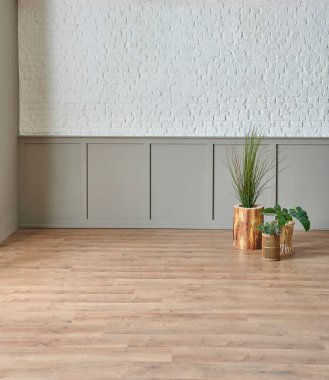 Duvarda beyaz tuğla ve klasik kahverengi desenler, altın vazo, kahverengi parke döşeme..