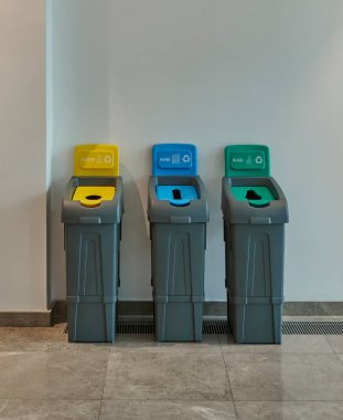 Üç renk geri dönüşüm kutusu, sarı plastik, mavi kağıt ve yeşil cam..
