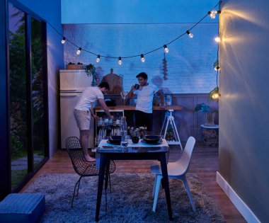 Aynı evde yaşayan iki adam, yemek yiyorlar, modern oda gece konsepti, mutfak ve oturma odası tarzı..