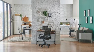 Tuğla duvar, sandalye, dizüstü bilgisayar ve ofis tarzı dekoratif çalışma odası. Lamba stili ahşap masa.