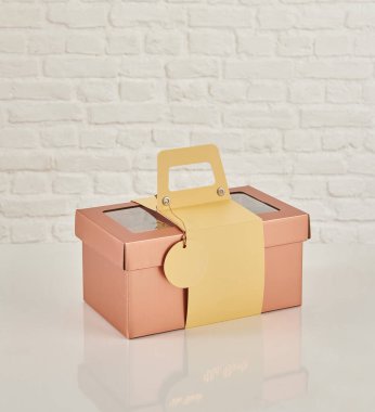 Güzel çiçek aranjmanları: portakal ve beyaz güllerden oluşan bir buket ve beyaz bir duvara karşı dekoratif çizgili bir kutuda pembe bir lale düzeneği..