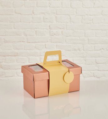 Güzel çiçek aranjmanları: portakal ve beyaz güllerden oluşan bir buket ve beyaz bir duvara karşı dekoratif çizgili bir kutuda pembe bir lale düzeneği..