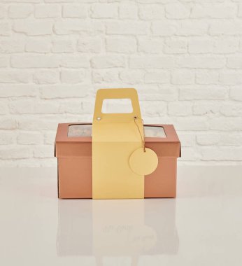 Güzel çiçek aranjmanları: portakal ve beyaz güllerden oluşan bir buket ve beyaz bir duvara karşı dekoratif çizgili bir kutuda pembe bir lale düzeneği..