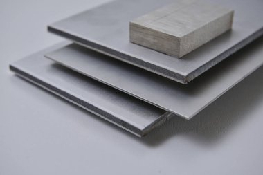 Metalik yüzey levhalarının görüntüsünü fırçalanmış ve mat bitkileriyle kapatın, mimari, imalat ve ürün tasarım uygulamaları için modern malzeme tasarımı ve endüstriyel dokular sergileniyor. İzole edilmiş beyaz arkaplan.