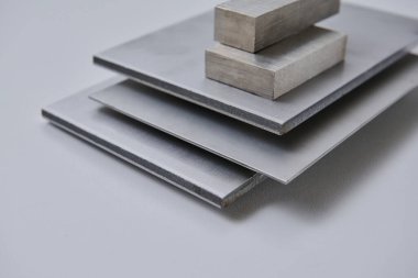 Metalik yüzey levhalarının görüntüsünü fırçalanmış ve mat bitkileriyle kapatın, mimari, imalat ve ürün tasarım uygulamaları için modern malzeme tasarımı ve endüstriyel dokular sergileniyor. İzole edilmiş beyaz arkaplan.