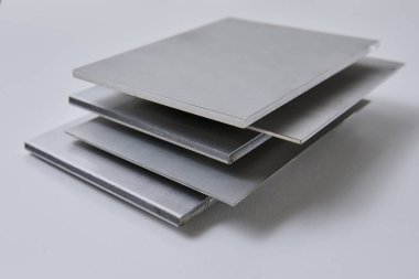 Metalik yüzey levhalarının görüntüsünü fırçalanmış ve mat bitkileriyle kapatın, mimari, imalat ve ürün tasarım uygulamaları için modern malzeme tasarımı ve endüstriyel dokular sergileniyor. İzole edilmiş beyaz arkaplan.