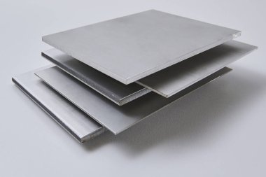 Metalik yüzey levhalarının görüntüsünü fırçalanmış ve mat bitkileriyle kapatın, mimari, imalat ve ürün tasarım uygulamaları için modern malzeme tasarımı ve endüstriyel dokular sergileniyor. İzole edilmiş beyaz arkaplan.