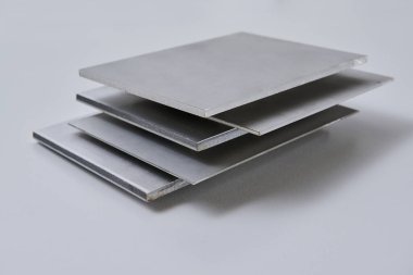 Metalik yüzey levhalarının görüntüsünü fırçalanmış ve mat bitkileriyle kapatın, mimari, imalat ve ürün tasarım uygulamaları için modern malzeme tasarımı ve endüstriyel dokular sergileniyor. İzole edilmiş beyaz arkaplan.