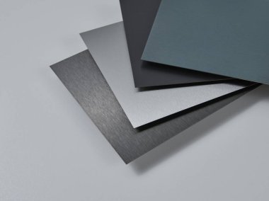 Metalik yüzey levhalarının görüntüsünü fırçalanmış ve mat bitkileriyle kapatın, mimari, imalat ve ürün tasarım uygulamaları için modern malzeme tasarımı ve endüstriyel dokular sergileniyor. İzole edilmiş beyaz arkaplan.