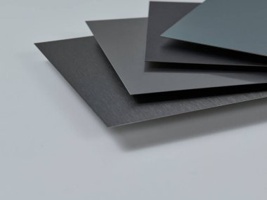 Metalik yüzey levhalarının görüntüsünü fırçalanmış ve mat bitkileriyle kapatın, mimari, imalat ve ürün tasarım uygulamaları için modern malzeme tasarımı ve endüstriyel dokular sergileniyor. İzole edilmiş beyaz arkaplan.