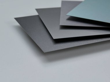 Metalik yüzey levhalarının görüntüsünü fırçalanmış ve mat bitkileriyle kapatın, mimari, imalat ve ürün tasarım uygulamaları için modern malzeme tasarımı ve endüstriyel dokular sergileniyor. İzole edilmiş beyaz arkaplan.