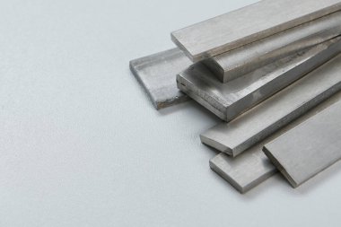 Yüksek kaliteli, paslanmaz çelik çubuklar ve düz endüstriyel yapıya sahip, inşaat, mühendislik, imalat ve endüstriyel tasarım kavramlarına uygun düz bölümler. İzole edilmiş beyaz arkaplan.