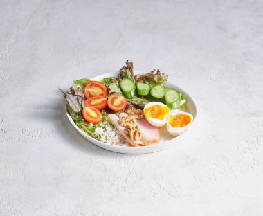 Temiz bir yüzeyde servis edilen yumurtalarla taze hazırlanmış kahvaltı tabağı, renk, doku ve iştah açıcı sunum..