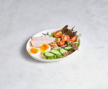 Temiz bir yüzeyde servis edilen yumurtalarla taze hazırlanmış kahvaltı tabağı, renk, doku ve iştah açıcı sunum..