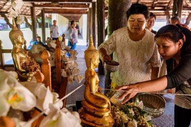 Chiang mai, Thailand - April 15, 2019 - People pour water over Buddha statues during the Songkran Days or traditional Thais New Year.