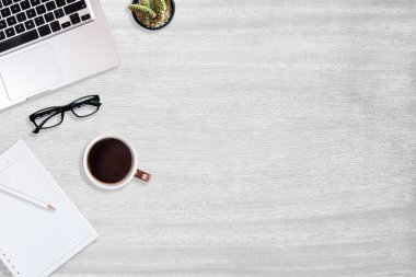 Modern beyaz ahşap ofis masası ve üzerinde fotokopi alanı olan sade kahveyle çalışmak için ekipman. düz ışın kavramı.