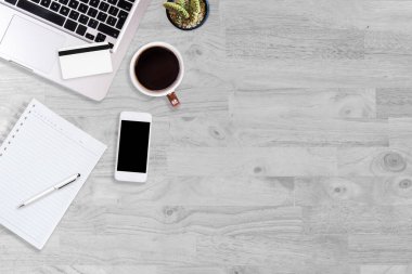 Modern beyaz ahşap ofis masası ve üzerinde fotokopi alanı olan sade kahveyle çalışmak için ekipman. düz ışın kavramı.