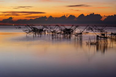 Güneşin doğuşu, Baan Pak Pra 'daki dev ağlar Thale Noi Wetlands ile avlanmak Tayland' ın Phatthalung şehrinin ünlü bir simgesidir..