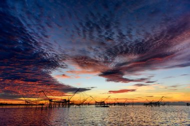 Güneşin doğuşu, Baan Pak Pra 'daki dev ağlar Thale Noi Wetlands ile avlanmak Tayland' ın Phatthalung şehrinin ünlü bir simgesidir..