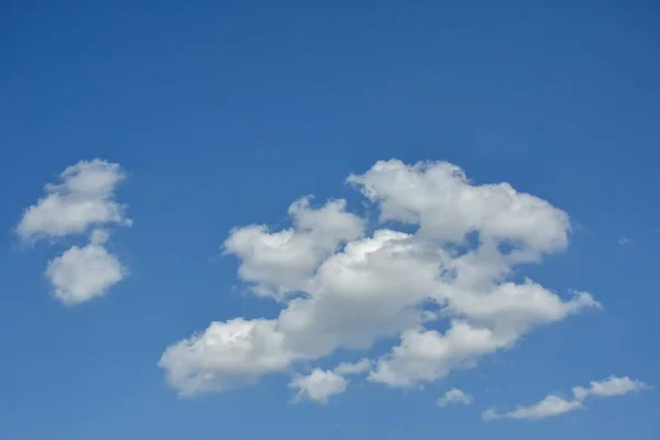 Beautiful cumulus clouds against the blue daytime sky. Cumulus is a fluffy cloud like a cotton ball.
