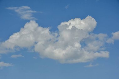 Güzel kümülüs bulutları mavi gündüz gökyüzüne karşı. Cumulus pamuk yumağı gibi yumuşak bir buluttur.. 