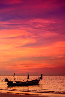 Deniz kıyısında günbatımı geçmişli bir balıkçı teknesi silueti. Phuket Adası, Tayland 'da deniz kenarında gün batımı anı