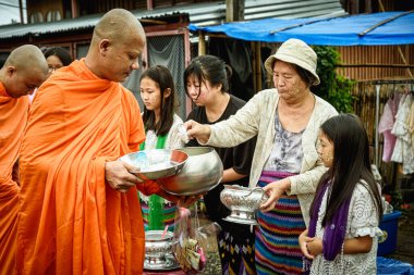 KANCHANABURI, THAILAND, EKİM 5, 2017: İnsanlar sabah bir Budist keşişe sadaka verecek. Bu ünlü kültür Thai - Sangklaburi 'deki Mon 