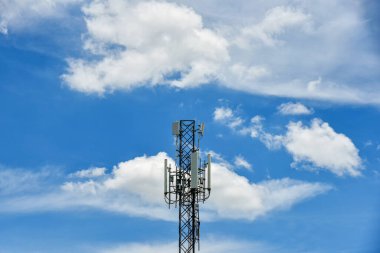Mavi gökyüzü arka planında hareket bulutları olan telekomünikasyon kuleleri. Mavi gökyüzünde kule sinyali. Beyaz bulutlar hareket ediyor.