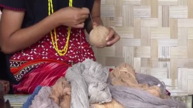 Kadın Karen Kabilesi geleneksel giysi ve el sanatları hazırlamak için kahverengi boyalı bir iplik topunu yuvarlıyor, Chiang Mai, Kuzey Tayland, Güneydoğu Asya