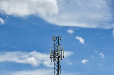 Mavi gökyüzü arka planında hareket bulutları olan telekomünikasyon kuleleri. Mavi gökyüzünde kule sinyali. Beyaz bulutlar hareket ediyor.
